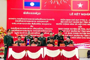 Representatives from Laos and Vietnam sign the agreement at the ceremony. (Photo: VNA)