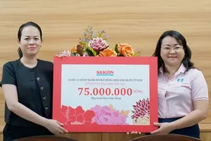 The representative of Sai Gon Giai Phong Newspaper (L) presents VND75 million in support for disadvantaged cancer patients receiving treatment at the Ho Chi Minh City Oncology Hospital. (Photo: SGGP)