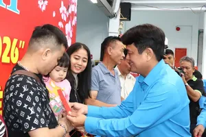 President of the Ho Chi Minh City Federation of Labor, Bui Thanh Nhan offers gifts to workers at the seeing-off ceremony. (Photo: SGGP)