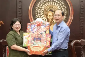 Vice Secretary of the Ho Chi Minh City Party Committee Van Thi Bach Tuyet (L) offers a gift to Secretary of the Ca Mau Provincial Party Committee Nguyen Ho Hai. (Photo: SGGP)