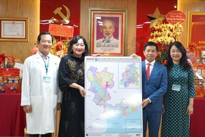 Ms. Bui Thi Hong Suong, Deputy Editor-in-Chief of Sai Gon Giai Phong Newspaper (2nd, L), presents the Map of Ho Chi Minh City’s Administrative Units to People's Hospital 115. (Photo: SGGP)
