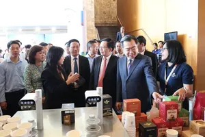 Mr. Nguyen Thanh Nghi, Member of the Politburo, Secretary of the Party Central Committee, and Head of the Central Committee's Policy and Strategy Commission, and Deputy Prime Minister Ho Quoc Dung visit exhibition booths showcasing Gia Lai’s signature products at the conference. (Photo: SGGP)