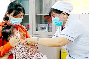 A healthcare worker administers vaccines to children. (Photo: SGGP)