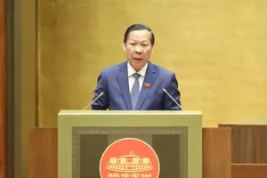 Chairman of the Committee for Economic and Financial Affairs, Phan Van Mai, presents the verification report on the draft resolution. (Photo: SGGP)