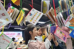 Children read books during the Spring Book Festival in Hanoi. (Photo: SGGP)