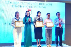 Chairwoman of HUFO, Ha Thanh, presents certificates of merit to representatives of foreign non-governmental organizations. (Photo: SGGP)