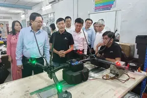 Deputy Prime Minister Ho Quoc Dung learns about UAV products at Real-Time Robotics Vietnam Joint Stock Company. (Photo: SGGP)