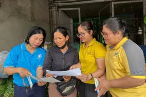Ho Chi Minh City Social Security staff members provide residents with information on voluntary social insurance and household health insurance policies. (Photo: SGGP)