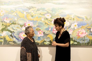 Artist Nguyen Thi Tam (left) talks with visitors at the exhibition. (Photo: SGGP)