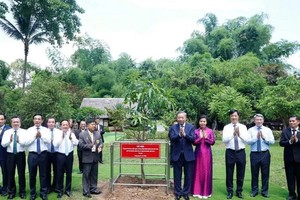 Party General Secretary and State President To Lam (fifth, left) and his spouse (fourth, left) plant a commemorative tree at the Ho Chi Minh Memorial Site in Udon Thani province on May 27. (Photo: VNA)