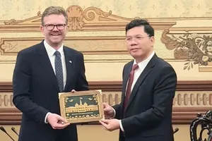 Vice Chairman of the Ho Chi Minh City People’s Committee Hoang Nguyen Dinh (R) presents a souvenir gift to the South Australian Minister for State Development, Chris Picton. (Photo: SGGP)