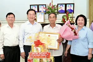 Standing Deputy Secretary of the HCMC Party Committee Le Quoc Phong (2nd, L) extends greetings to Mr. Nguyen Van Tan, 90, an elderly person in Phuoc Thanh Commune (2nd, R), on June 8. (Photo: SGGP)
