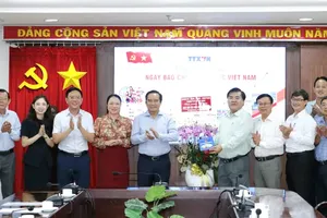 Chairman of the HCMC People's Committee Nguyen Van Duoc (5th, L) presents a gift to the Southern Regional Information Center of the Vietnam News Agency. (Photo: SGGP)