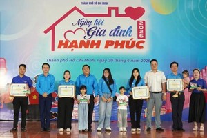 Chairman of the Ho Chi Minh City Vietnam Youth Union Le Tuan Anh and delegates offers gifts to families. (Photo: SGGP)
