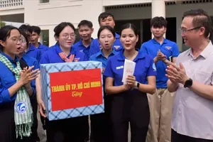 Mr. Dang Minh Thong presents gifts to the “Digital Summer” team supporting residents at Long Tan Market, Dat Do Commune, HCMC. (Photo: SGGP)