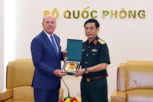Deputy Prime Minister and Minister of National Defense General Phan Van Giang (R) offers a gift to Canadian Ambassador to Vietnam James Nickel. (Photo: BQP)