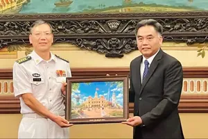 Standing Vice Chairman of the Ho Chi Minh City People's Committee Nguyen Loc Ha (R) offers a gift to Senior Colonel Liu Zhanfeng. (Photo: SGGP)