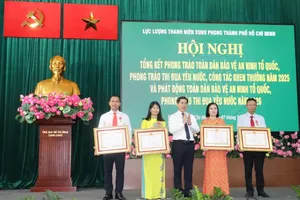 Commander of the Ho Chi Minh City Youth Volunteer Force Trieu Do Hong Phuoc presents the President's Third-Class Labor Orders to outstanding individuals. (Photo: SGGP)