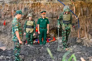 Officers and soldiers inspect the excavation site for unexploded ordnance while searching for the remains of fallen soldiers at Le Thi Rieng Park in Hoa Hung Ward, Ho Chi Minh City. (Photo: SGGP)