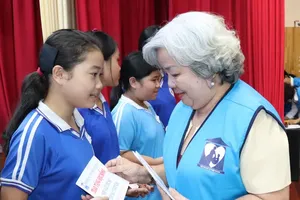 A representative of the Ho Chi Minh City Women's Charity Association presents scholarships to high-achieving students from disadvantaged backgrounds. (Photo: SGGP)