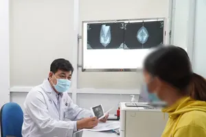 Assoc. Prof. Dr. Huynh Quang Khanh, Head of the Breast Surgery Department at Cho Ray Hospital, examines a patient. (Photo: SGGP)
