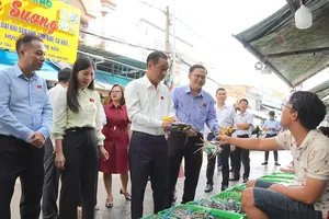 Vice Chairman of the Ho Chi Minh City People’s Council, Huynh Thanh Nhan (third from left) visits household businesses at Xom Luoi Seafood Market. (Photo: SGGP)