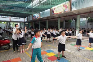 Students at Chuong Duong Primary School in Cau Ong Lanh Ward, HCMC exercise during recess. (Photo: SGGP)