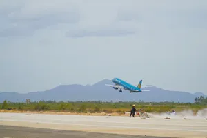 Workers use sweeping machines to clean the newly built runway at Phu Cat Airport. (Photo: SGGP)