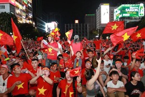 The red flag with a yellow star stands out amid crowds on Ho Chi Minh City streets during the victory celebrations.