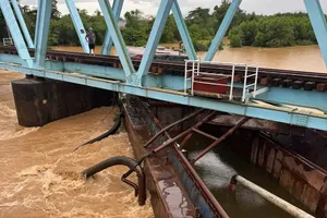 A barge is stuck at the base of the My Chanh railway bridge. (Photo: SGGP)