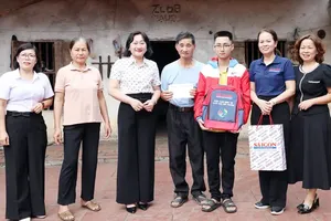 SGGP Newspaper Deputy Editor-in-Chief Bui Thi Hong Suong (third from left) visits and presents gifts to Nguyen Duc Hieu and his family in Van Nham Commune, Lang Son Province. (Photo: SGGP)