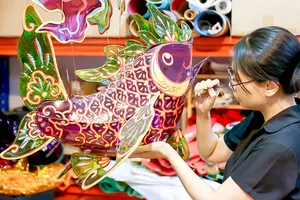 Artisan Nguyen Thi Kim Thuy puts the finishing touches on a carp-shaped lantern. (Photo: SGGP)