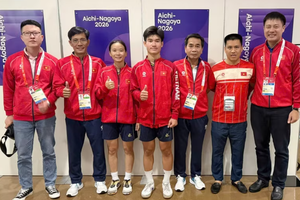 Teqball players Trinh Gia Nghi (third from left), Nguyen Hoang Minh Tan (fourth from left) and their coaches pose for a photo after winning a bronze medal at the 20th ASIAD. (Photo published by VNA)