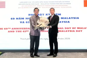 Ho Chi Minh City Union of Friendship Organizations Chairman Tran Ngoc Son (right) presents flowers to Malaysian Consul General in Ho Chi Minh City Firdauz Bin Othman. (Photo: SGGP)