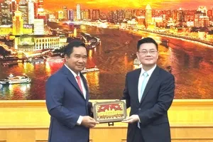 Chairman of the Ho Chi Minh City People’s Committee Nguyen Van Duoc (L) presents a gift to Mr. Wu Wei Ping, (Photo: SGGP)