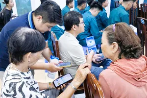 Nhân viên Công ty Cấp nước hướng dẫn và hỗ trợ người dân cài đặt ứng dụng SAWACO CSKH