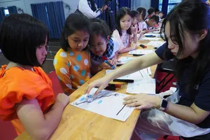 Sinh viên Hàn Quốc hướng dẫn học sinh Trường Tiểu học Lê Đức Thọ điều khiển robot mini