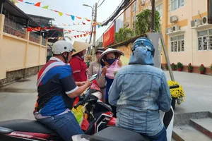 Phụ huynh Trường Tiểu học Nguyễn Văn Hưởng (phường Phú Thuận) mang cơm tới trường cho con vào trưa 29-1 