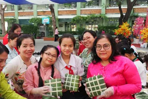 Học sinh, phụ huynh và giáo viên phấn khởi với những chiếc bánh chưng vừa gói tại hoạt động trải nghiệm "Gói bánh chưng ngày tết"