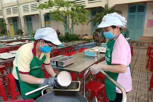 Nhân viên phục vụ bán trú phân chia suất ăn tại Trường THCS Võ Trường Toản (phường Sài Gòn). Ảnh minh họa.