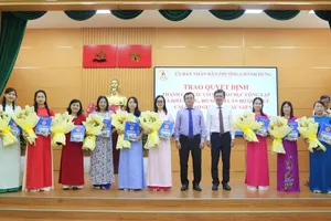 Chủ tịch UBND phường Chánh Hưng Phạm Quang Tú (thứ 7 từ trái sang) trao các quyết định hiệu trưởng, phó hiệu trưởng sau sắp xếp cơ sở giáo dục