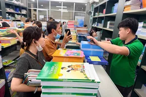 Phụ huynh mua SGK cho con tại trụ sở NXBGDVN tại TPHCM vào trưa 15-9. Ảnh: HOÀNG HÙNG