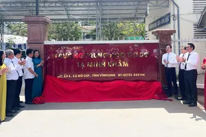 Các đại biểu thực hiện nghi thức gắn biển tên trường