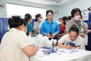 Nữ công nhân điền thông tin để được kiểm tra sức khỏe, tầm soát ung thư tại chương trình