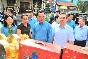 Đồng chí Nguyễn Đình Khang và đồng chí Nguyễn Phước Lộc tham quan gian hàng "Chợ Tết Công đoàn" tại TPHCM. Ảnh: VIỆT DŨNG