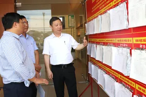 Trưởng Ban Tuyên giáo và Dân vận Thành ủy TPHCM Dương Anh Đức kiểm tra khu vực niêm yết danh sách người ứng cử tại điểm bỏ phiếu xã Tân Vĩnh Lộc. Ảnh: THÁI PHƯƠNG