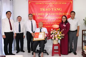 Phó Bí thư Thành ủy TPHCM Nguyễn Phước Lộc trao Huy hiệu 80 năm tuổi Đảng đến đồng chí Phạm Ngọc Ẩn. Ảnh: THÁI PHƯƠNG