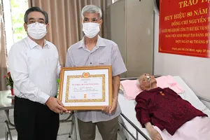 Phó Bí thư Thành ủy TPHCM Nguyễn Phước Lộc trao Huy hiệu 80 năm tuổi Đảng đến đồng chí Nguyễn Thị Phụng (thông qua người thân trong gia đình). Ảnh: VIỆT DŨNG.