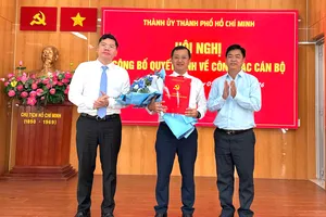 Đồng chí Hoàng Nguyên Dinh và đồng chí Lê Văn Minh trao quyết định, tặng hoa chúc mừng đồng chí Tạ Quốc Trung. Ảnh: THÁI PHƯƠNG
