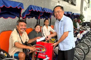 Niềm vui của người khuyết tật khi nhận xe lắc tay. Ảnh: HỒNG HẢI